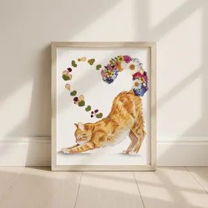 A cat and a heart of pressed flowers in a white frame